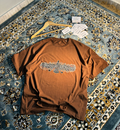 Persian Calligraphy Oversized Tee Brown – flat lay on rug angle 1