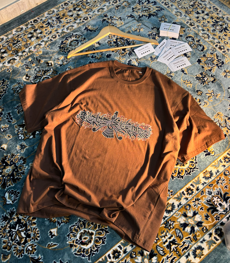 Persian Calligraphy Oversized Tee Brown – flat lay on rug angle 4